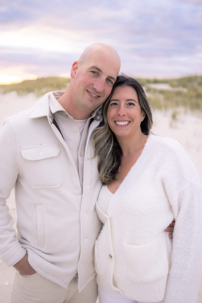 Family portrait with husband and wife at sunset on Florida beach