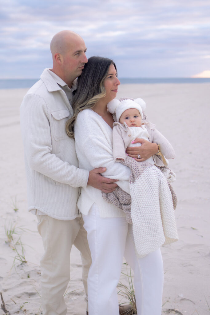 Family standing together by ocean during Central Florida sunset photoshoot