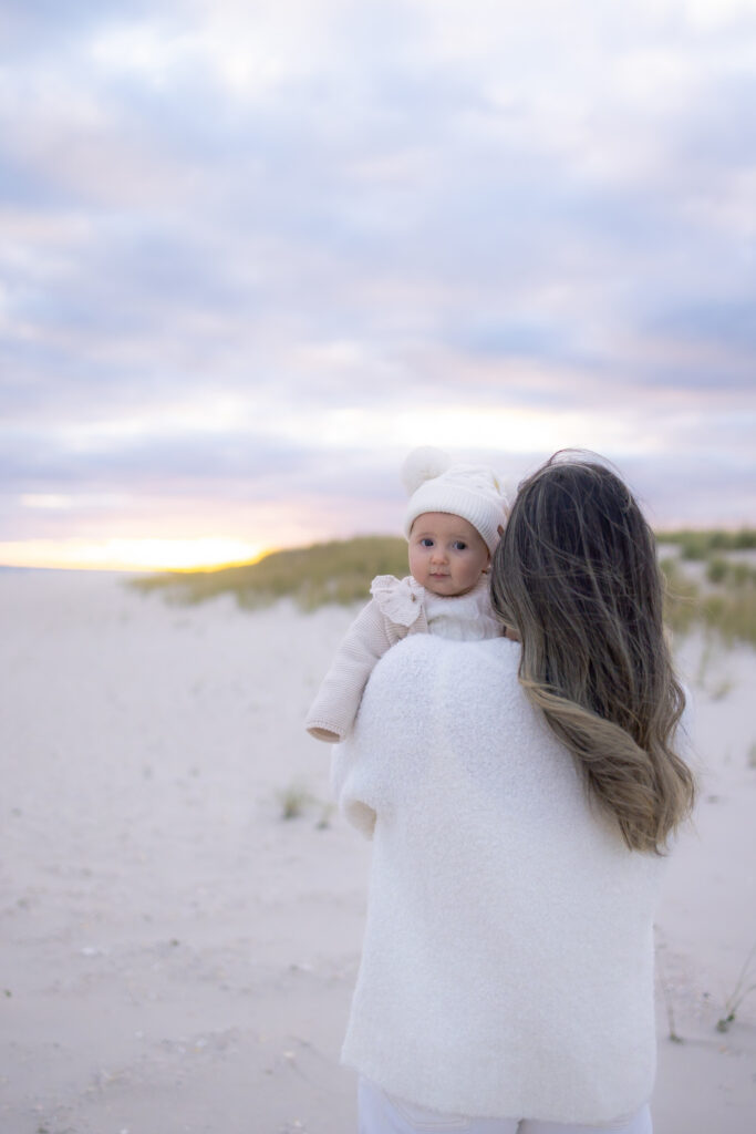 Candid beach family session with three generations at sunset