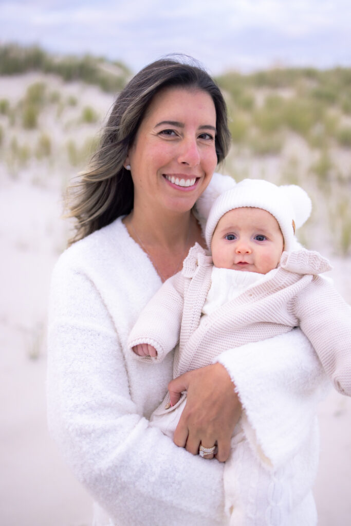 Mother posing with newborn at sunset in Florida beach photo session