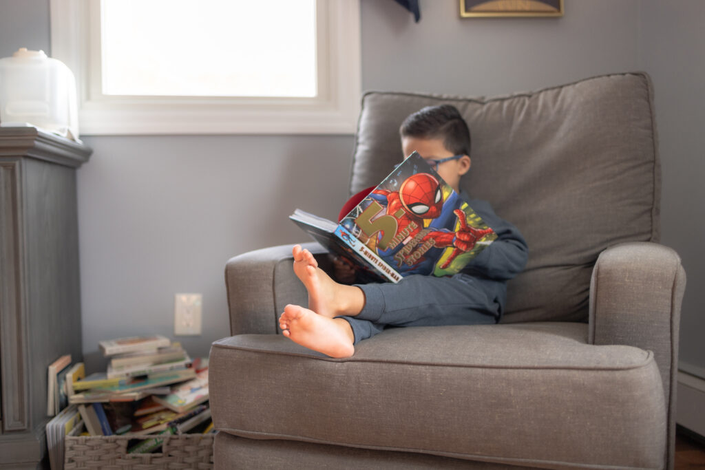 Toddler boy reading book in natural lifestyle photography session
