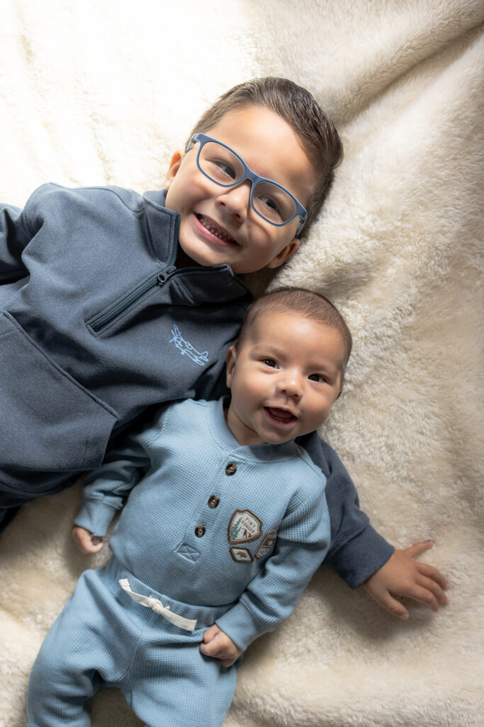 Older brother interacting with newborn during family lifestyle session