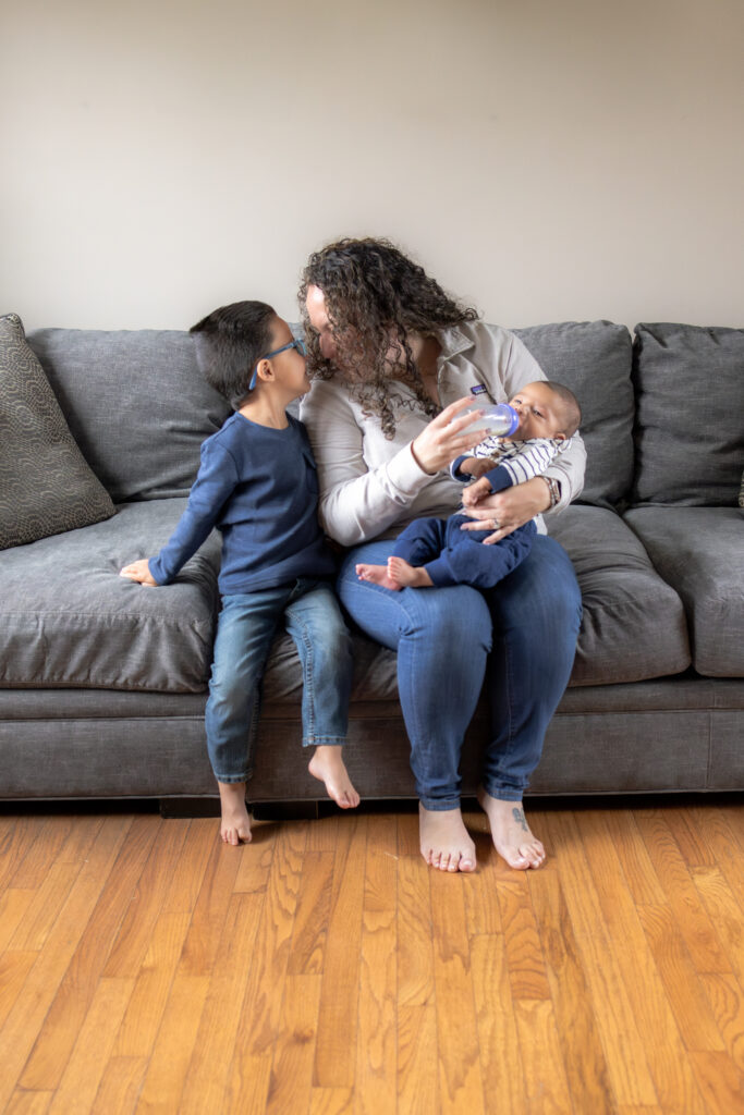 Mother holding newborn baby during in-home family photography session