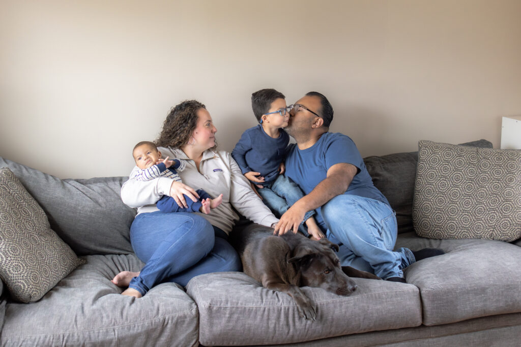 Parents holding newborn and toddler during relaxed lifestyle family photos
