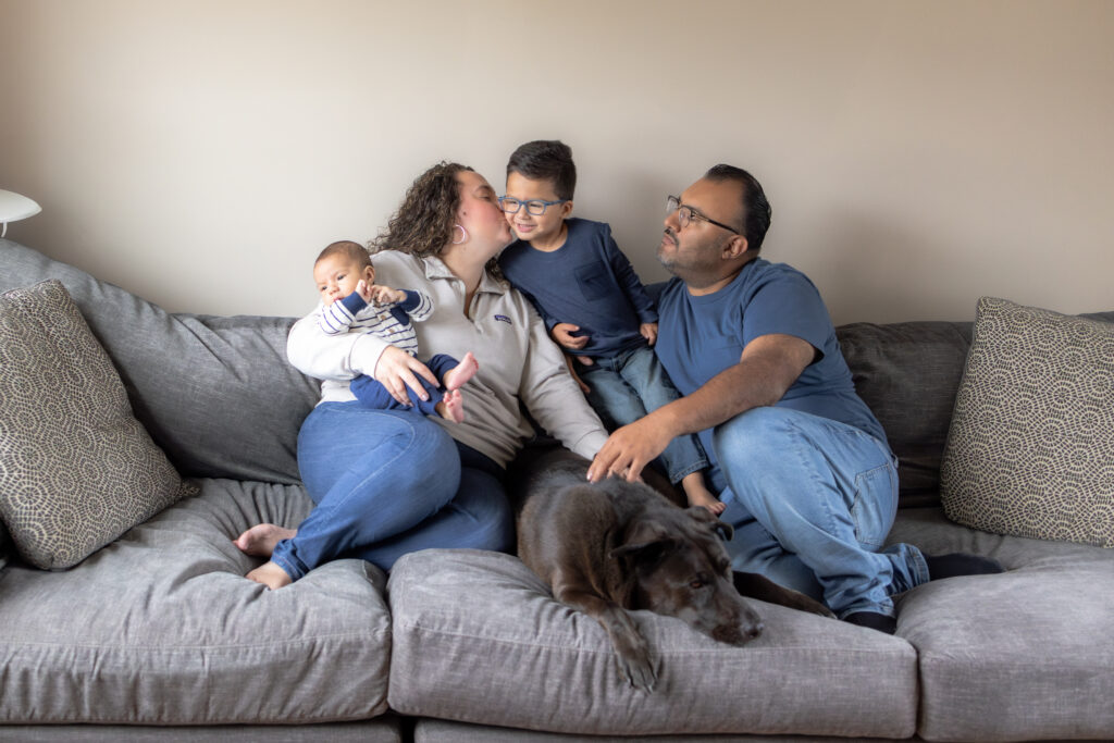 family cuddling on couch in comfortable in-home photography session