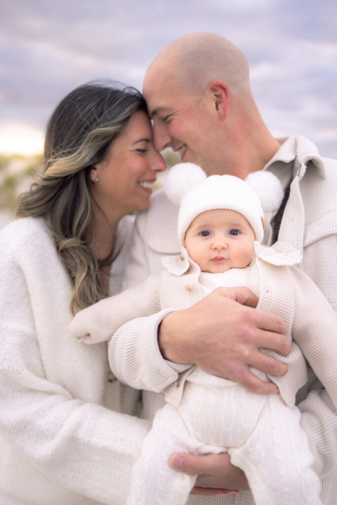 Family embracing together on beach during golden hour photography session