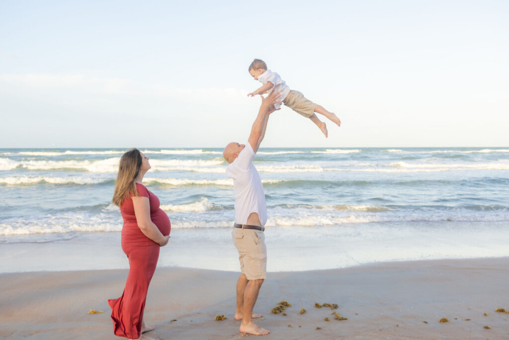 intimate couple playing with son at ormond beach