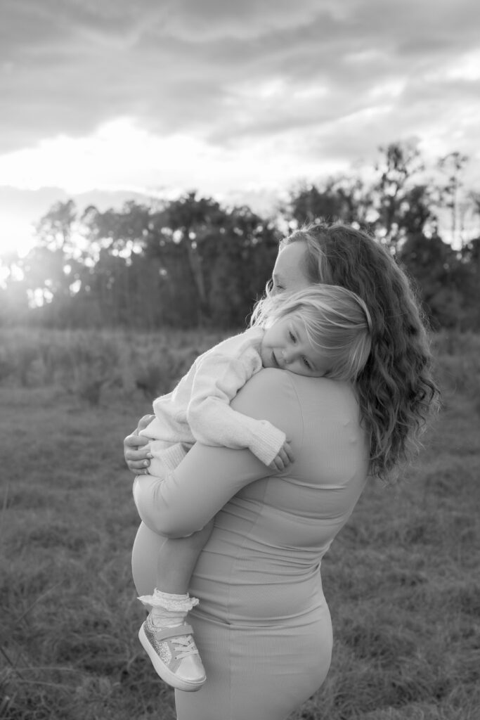 An upscale outdoor maternity session showing a family of four seamlessly styled in neutral wardrobe pieces from the studio client closet.